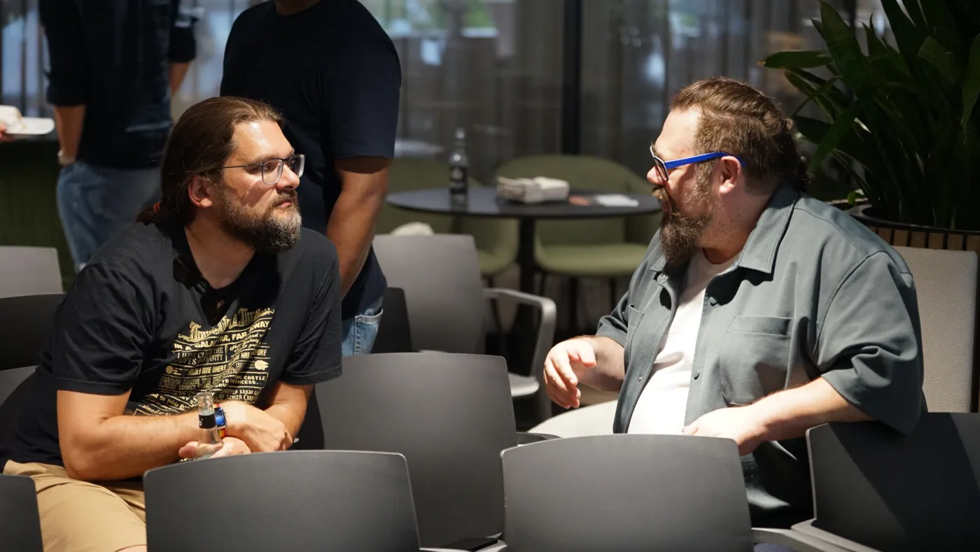 Zwei Teilnehmer mit Laptops im Gespräch beim Networking