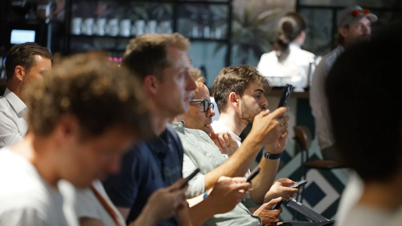 Teilnehmerreihe folgt dem Talk – einige machen Notizen und Fotos der Folien