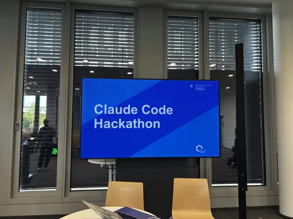 Raum im IT-Rathaus mit dem Bildschirm „Claude Code Hackathon“ vor dem Start des Impact Labs